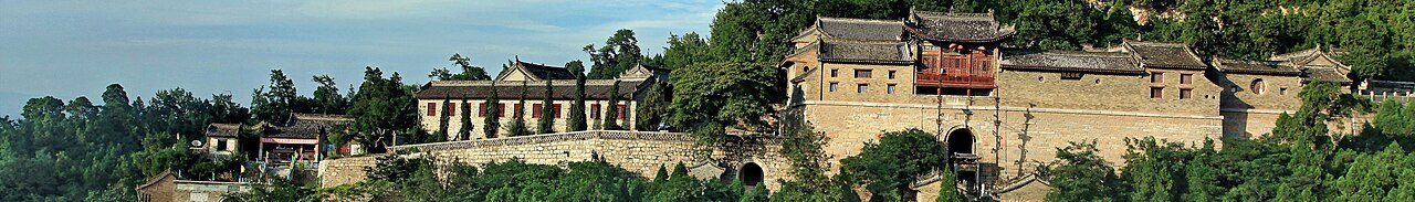药王山山体与山顶建筑群的全景，山前为城区建筑